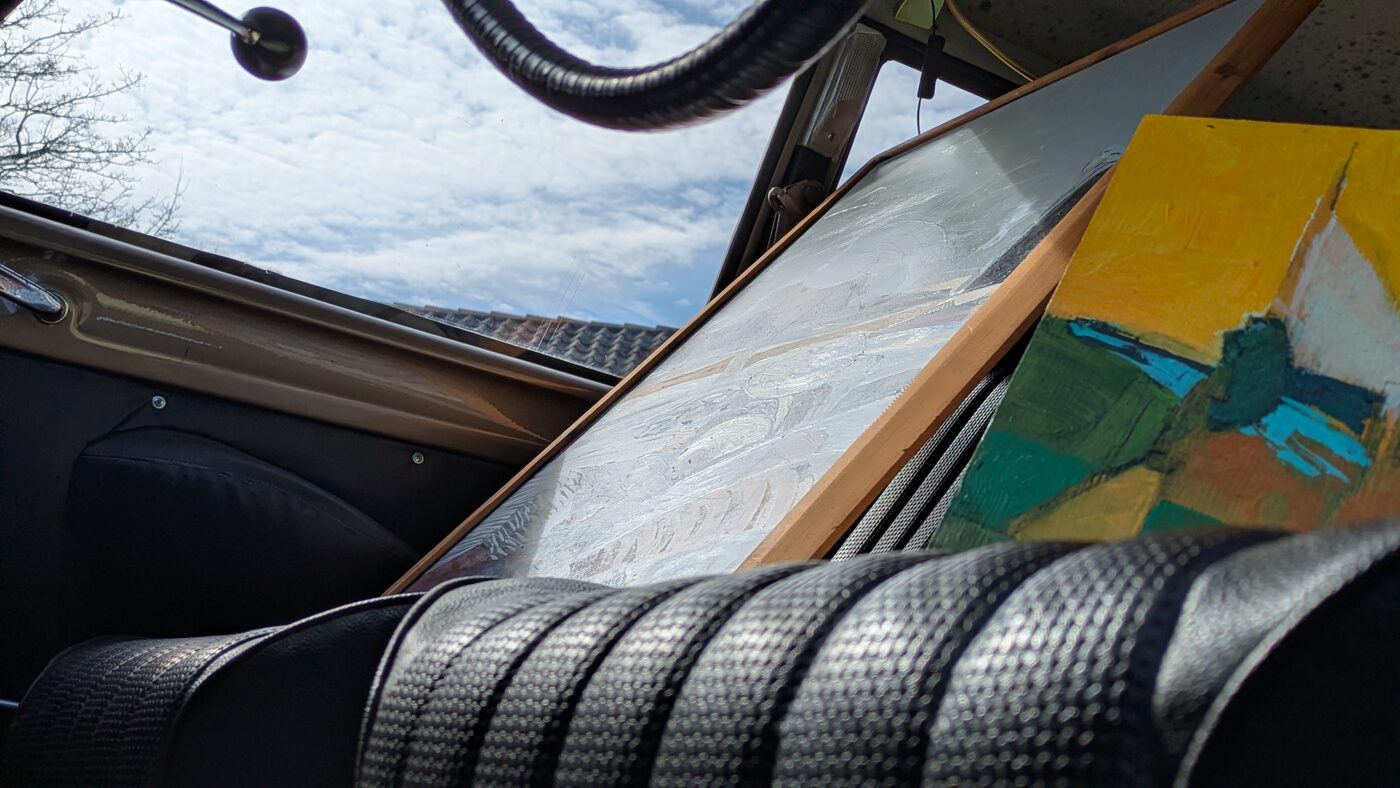 The dashboard of the car with sky reflected in the glass