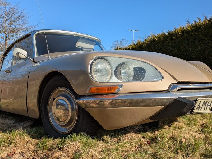 DS, a Citroën with paintings inside, parked on grass