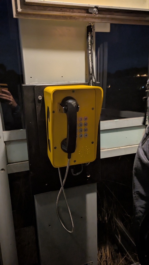 The yellow handset mounted on the wall inside the booth